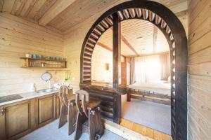 a kitchen with an archway in a log cabin at Хата Різьбяра in Beloberëzka