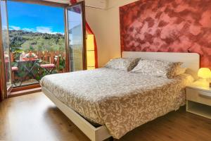 a bedroom with a bed and a large window at Dal Rosso in San Floriano del Cóllio