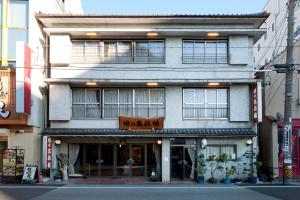 a building with a sign on the front of it at Hinode Ryokan in Ise