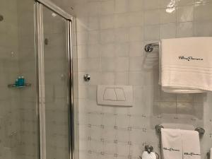 a bathroom with a shower and a white towel at Villino Eleonora in Parghelia