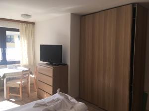 sypialnia z łóżkiem i telewizorem na komodzie w obiekcie Alpenpension Haslinger w mieście Bad Gastein