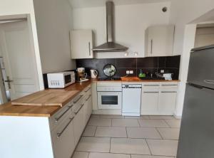 a kitchen with white cabinets and white appliances at Gîte Les Rapières in Gordes