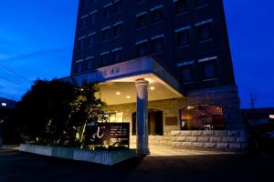 un edificio con un cartello davanti di Station Hotel AU a Tsu