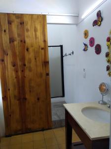a bathroom with a wooden door next to a sink at Casona Tlaquepaque Temazcal & Spa in Guadalajara