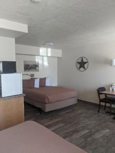 a bedroom with a bed and a table with a table at Little Daisy Motel in Cottonwood