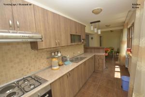a large kitchen with wooden cabinets and a sink at Vernisaj apt at Republic Square & Ruben tours in Yerevan