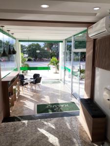 a living room with glass doors and a table and chairs at Kaluff Hotel in Itaboraí
