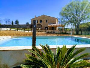 a swimming pool with a house in the background at Cal Menescal in Les Olives