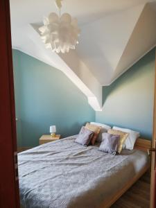 1 dormitorio con 1 cama con paredes azules y techo blanco en Złoty Piasek, en Darłowo