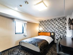 een hotelkamer met een bed en een bureau bij APA Hotel Sapporo Housuisusukino Ekimae in Sapporo