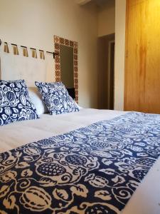 a bed with blue and white blankets and pillows at Pied à Terre at Casitas Aparicio in San Miguel de Allende