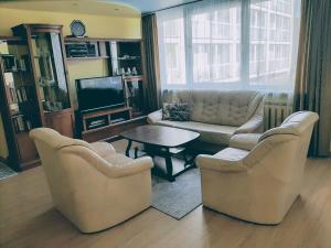 a living room with two chairs and a couch and a table at Irene apartments in Druskininkai