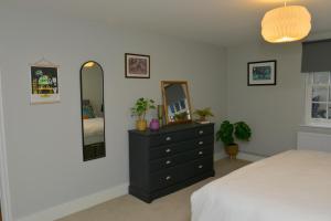 um quarto com uma cómoda preta e um espelho em 10A Ruston Chambers Free parking, Luxury 2 bedroom city center apartment em St Ives