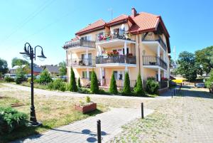 a large building with balconies on a street at Apartamenty Rybacka 84A m17 in Krynica Morska