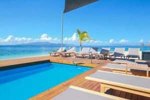 a pool with chairs and the ocean in the background at Serenity Island Resort in Bounty Island
