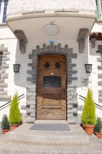 a large wooden door on a building with plants at Hôtel-Restaurant de la Tour in Bulle