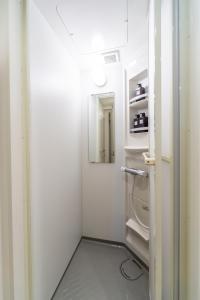 małą, białą lodówkę z otwartymi drzwiami w obiekcie GIVE Araiyakushi w Tokio
