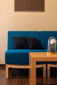 a blue couch sitting next to a wooden table at Bijou Suites Miyabi in Osaka