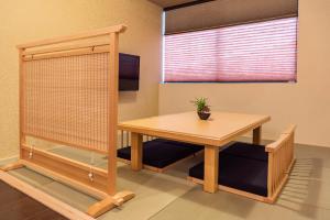 een kamer met een houten tafel en een raam bij Bijou Suites Miyabi in Osaka