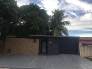 ein Haus mit einer Garage mit einer Palme dahinter in der Unterkunft Casa Temporada Castro Alves in Bonito