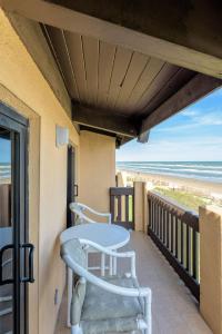 a balcony with a table and chairs on the beach at Tiki 332 in South Padre Island