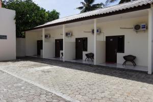a building with black doors and chairs in a courtyard at SUPER OYO 3024 Hotel Kebon Manis in Cilacap