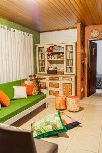 ein Wohnzimmer mit einer grünen Couch und einem Bücherregal in der Unterkunft Casa Wilma Dinnebier Hospedagem in Gramado