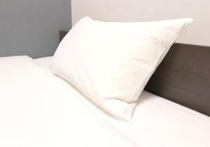 a pillow sitting on top of a bed at Hotel Trend Abeno Tennoji in Osaka