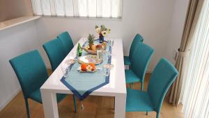una mesa de comedor con sillas azules y un plato de comida en Ecot Shimozato 1, en Isla Miyako