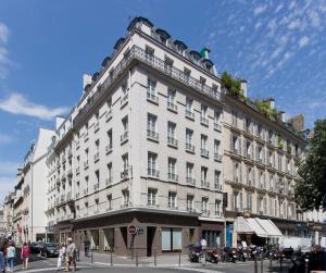 a large white building on the corner of a street at Hôtel Duo in Paris