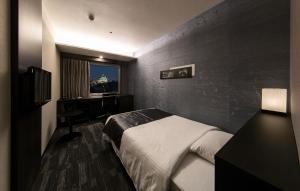 Een bed of bedden in een kamer bij KKR Hotel Osaka