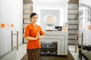 Eine Frau steht in einem Zimmer mit Kamin in der Unterkunft HARRIS Hotel & Conventions Malang in Malang + 37 Fotos
