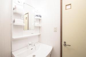 un bagno bianco con lavandino e specchio di AMP FLAT Tenjin Minami Ⅱ a Fukuoka