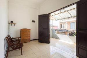 a room with a door and a chair and a balcony at RedDoorz near Widya Mandala University in Surabaya