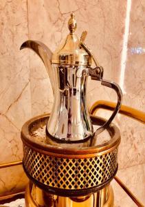 a silver tea kettle sitting on top of a basket at Vision Apartment in Buraydah