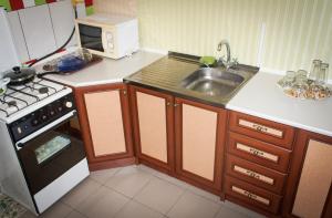 a small kitchen with a sink and a stove at Vesela Bdzhilka in Sumy