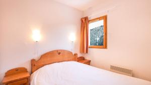 a bedroom with a bed with two lights on at Vacancéole - Résidence Les Chalets de la Ramoure in Valfréjus +28 photos