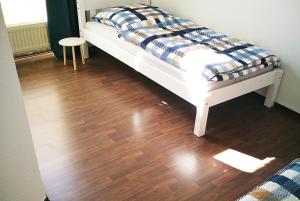 een bed met een geruite deken op een houten vloer bij Work & Stay in Emmerich in Emmerich