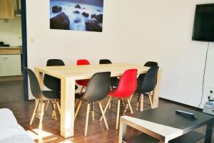Work & Stay in Emmerich في إميريش: طاولة غرفة طعام مع كراسي حمراء وطاولة