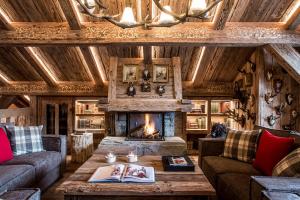 sala de estar con sofá y chimenea en Le Refuge de la Traye en Méribel