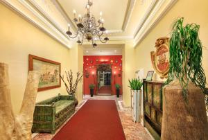 a hallway with a red carpet and a chandelier at Das Gutenbrunn Thermen & Sporthotel in Baden