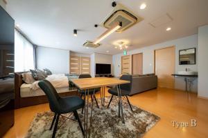 salon z łóżkiem, stołem i krzesłami w obiekcie HOTEL er. w mieście Kobe