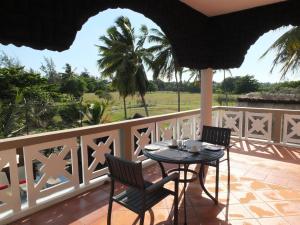 een patio met een tafel en stoelen op een balkon bij Eden Villa in Belle Mare