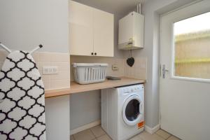 a laundry room with a washing machine and a window at Luxury Boutique House - Close to MK City Center in Milton Keynes