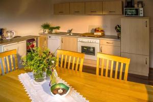 a kitchen with a wooden table with chairs and a tableasteryasteryasteryasteryastery at Haus Bergblick in Oy-Mittelberg +13 photos