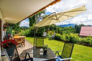a patio with a table and an umbrella at Haus Bergblick in Oy-Mittelberg