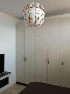 a large chandelier in a room with cabinets at VELVET RESIDENCE in Mamaia Sat/Năvodari