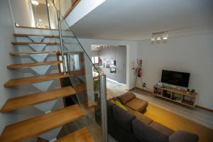 a living room with a couch and a staircase at Casa do Califórnia in Ribeira Grande