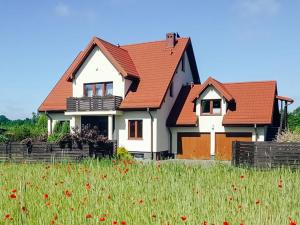 a house with red roofs in a field of flowers at Active Room in Suwałki