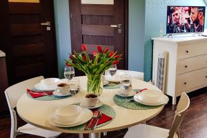 a white dining room table with plates and wine glasses at Active Room in Suwałki